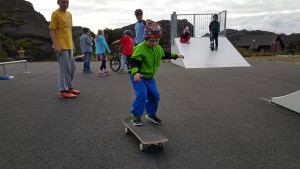 Volontøren Steven (i bakgrunnen) gav tips til ungdomane om skateboarding. Daniel Elvevåg prøvar seg.